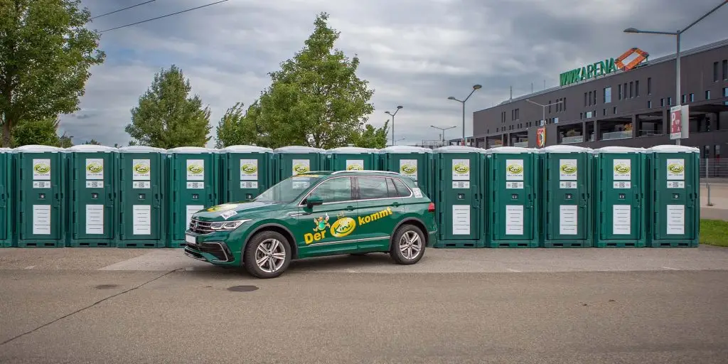 reihe-an-mobile-toilette-grün-vor-auto